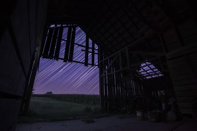 夜晚，棕色木屋上方的星星长时间曝光